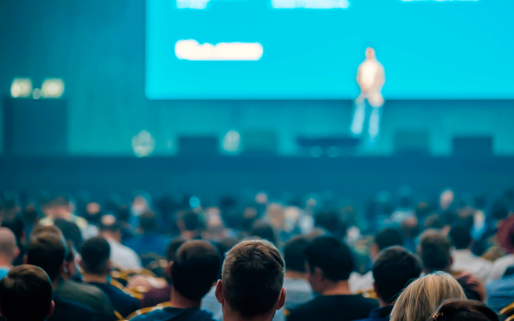 fotografia del pubblico e del palco con uno speaker ad un evento